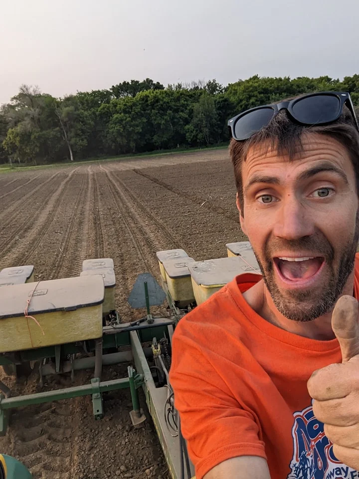 Aaron Brand riding tractor through sunflower field planting